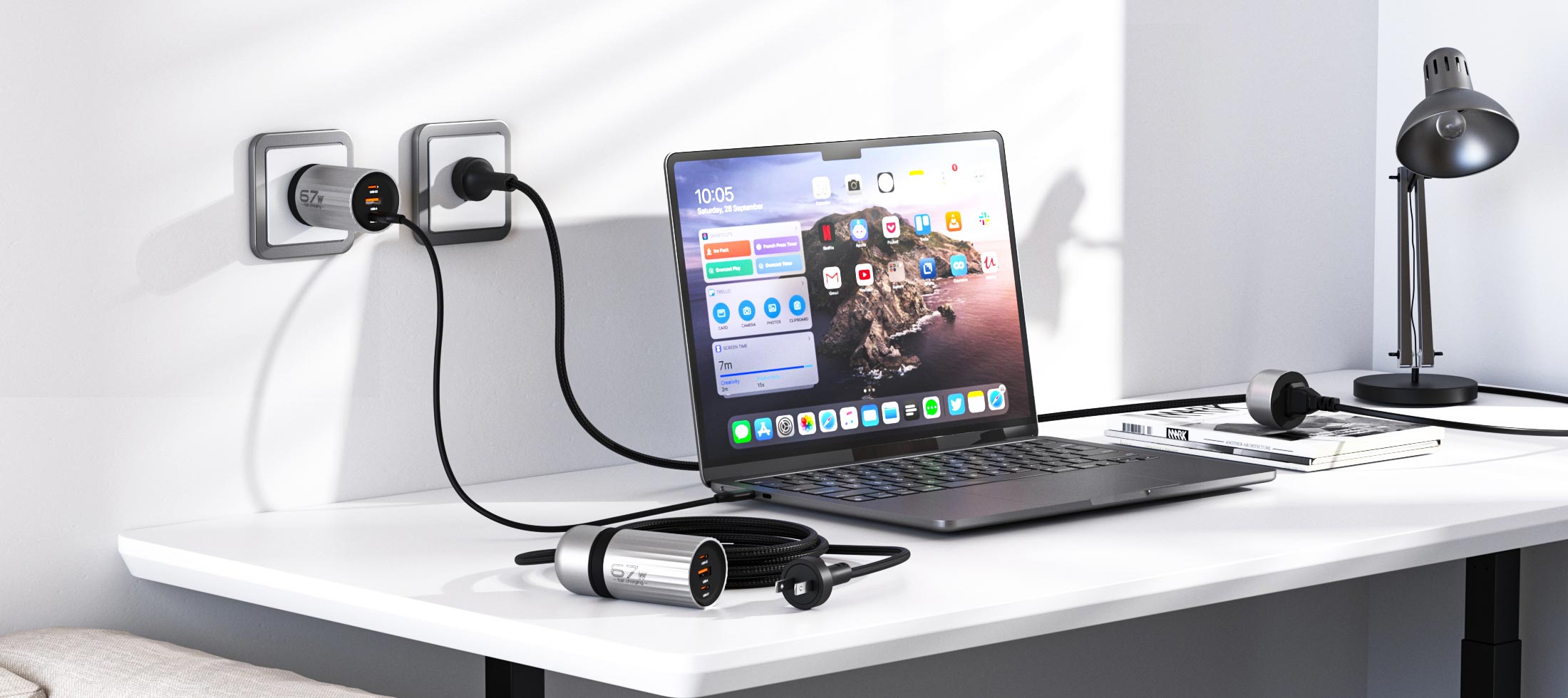 Laptop on a desk with a power adapter and multiple plugs plugged into an outlet.